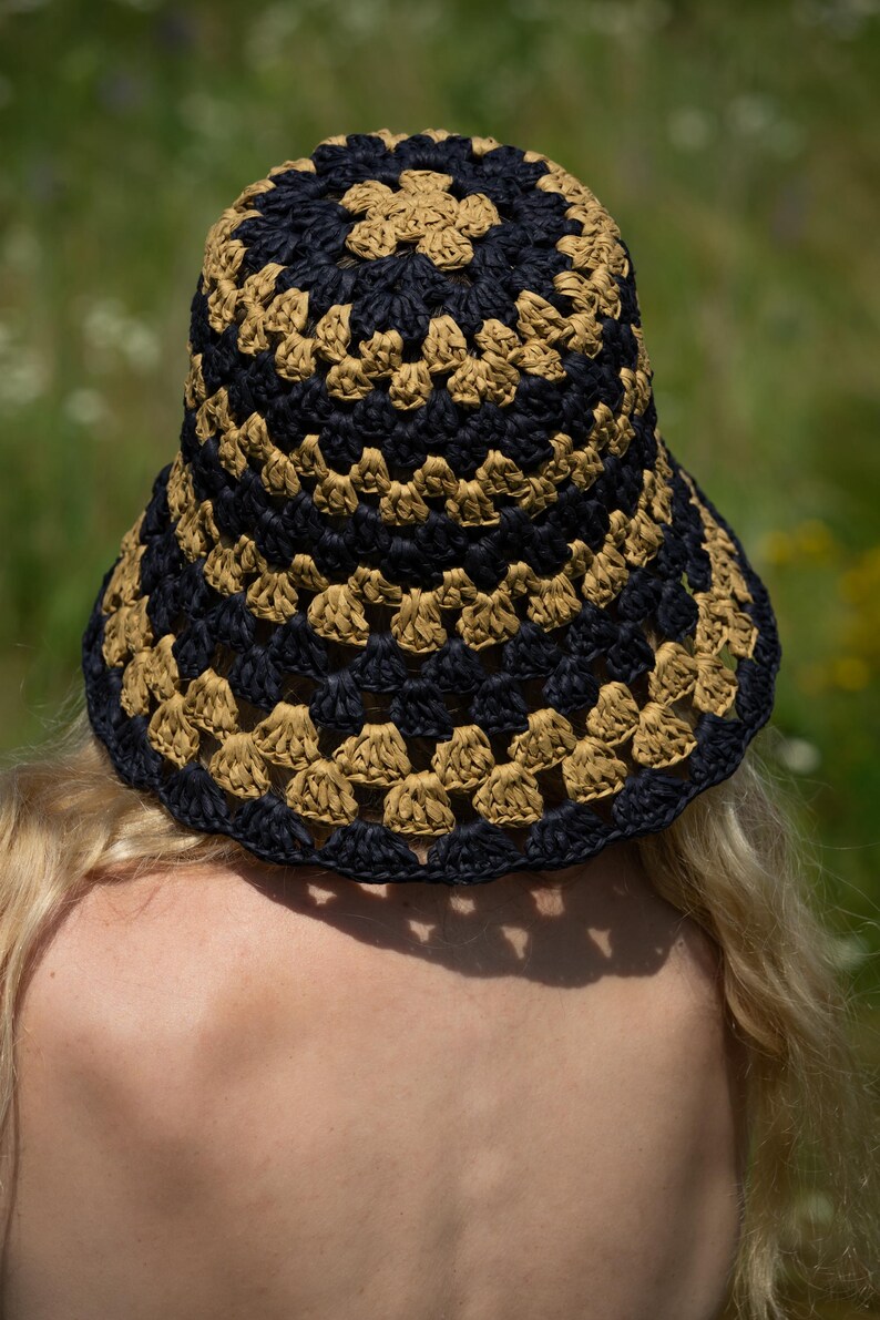 May include: A black and tan crocheted bucket hat with a wide brim.
