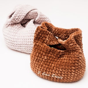 May include: Two handmade crochet bags in soft, textured yarn. One is light beige, the other is a rich brown. The brown bag has the text "I Love Create" on the side. These bags are ideal for carrying small items.