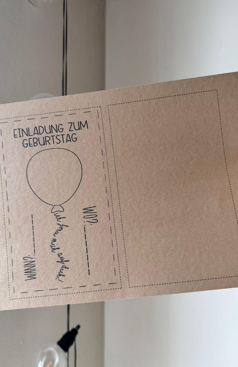 Pode incluir: Um cart&atilde;o castanho com uma borda preta e o texto "Einladung zum Geburtstag" (Convite de anivers&aacute;rio) e um gr&aacute;fico de um bal&atilde;o. O cart&atilde;o tem espa&ccedil;os em branco para escrever a data, a hora e o local da festa de anivers&aacute;rio.