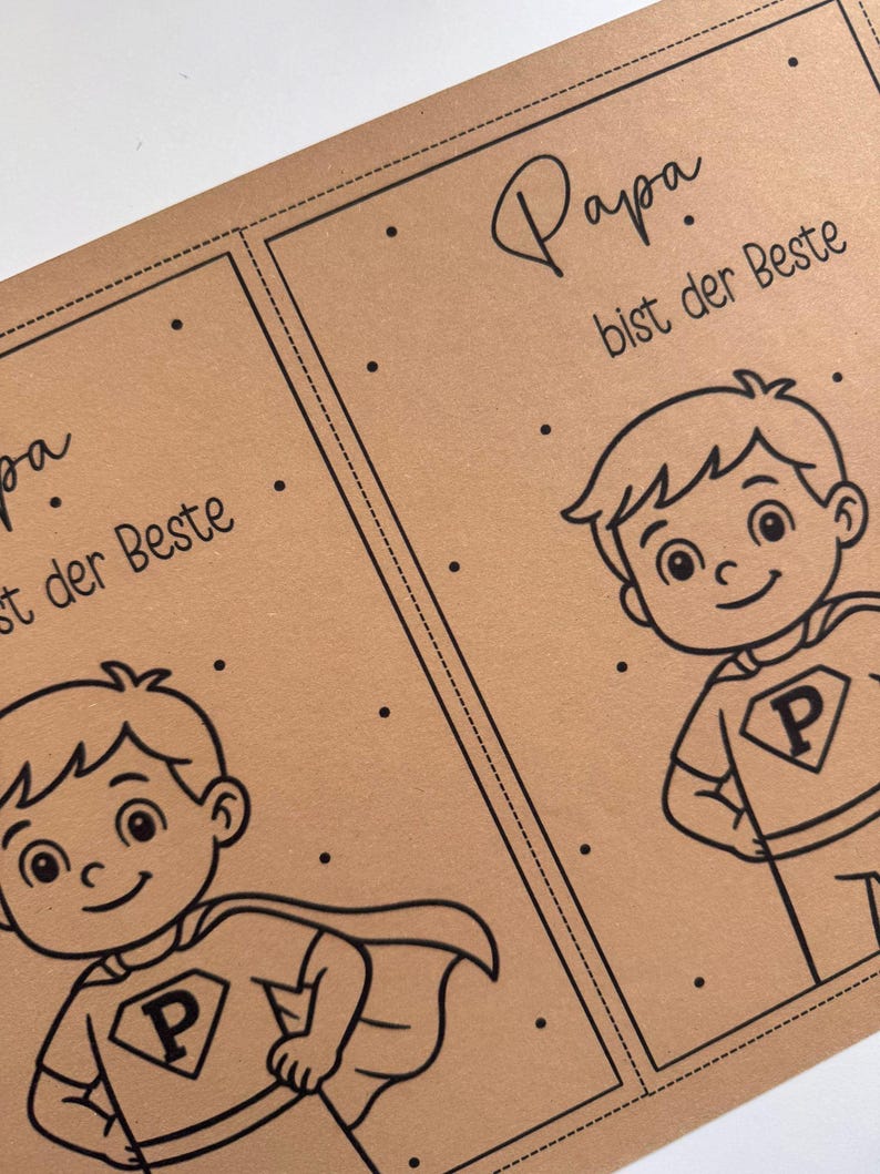 May include: Two brown cards with black line art. Each card features a cartoon superhero boy with a cape and the letter "P" on his shirt. The text "Papa bist der Beste" is written in script above the boy.
