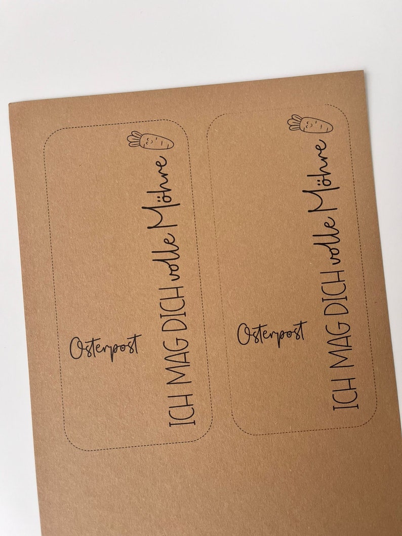 May include: Two brown paper cards with rounded corners and black text. The text on the left card reads "Osterpost ICH MAG DICH volle M&ouml;hre". The text on the right card reads "Osterpost ICH MAG DICH volle M&ouml;hre".