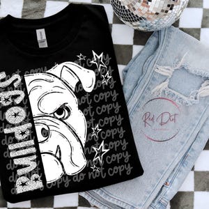 May include: Black t-shirt with a white bulldog graphic and the word "Bulldogs" in a vertical font. The shirt is paired with light-wash, distressed jeans and a disco ball. The words "do not copy" are repeated on the shirt.