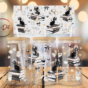 May include: Three glass jars with wooden lids, each featuring a black dragon perched on a stack of books. The design includes bows, hearts, and coffee cups. A decorative print with the same design hangs above.