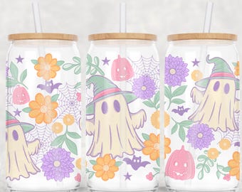 May include: Three glass beverage cups with wooden lids and straws. Each cup features a whimsical Halloween design with ghosts, pumpkins, flowers, and bats in pastel colors. The cups are perfect for seasonal drinks.