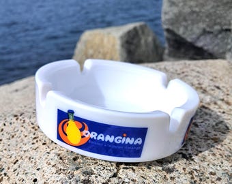 Cenicero de cristal blanco ORANGINA con botella y logotipo vintage de Orangina.