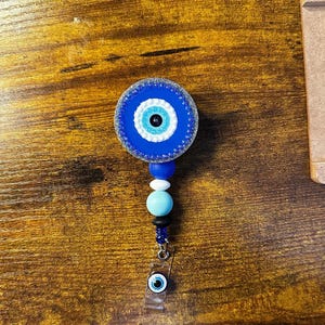 Handgemachte Evil Eye Bedazzled Abzeichen Reel mit hängenden Silikonperlen