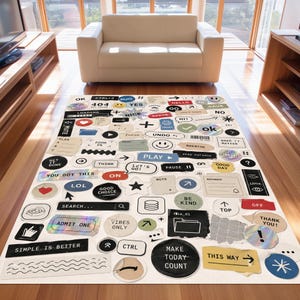 Könnte beinhalten: Ein rechteckiger Teppich mit einer Collage aus verschiedenen Computer-Schnittstellensymbolen, Sprechblasen und Textetiketten wie "OK", "CTRL+Z", "404", "HELLO", "PLAY", "PAUSE", "SEARCH", "ADMIT ONE", "VIBES ONLY" und "MAKE TODAY COUNT".