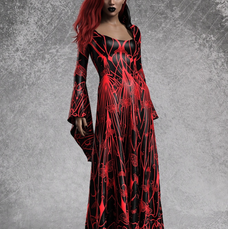 May include: A long, black dress with a red, intricate pattern. The dress features long, flared sleeves and a square neckline. The model has red hair and dark lipstick. The dress has a gothic or fantasy theme.