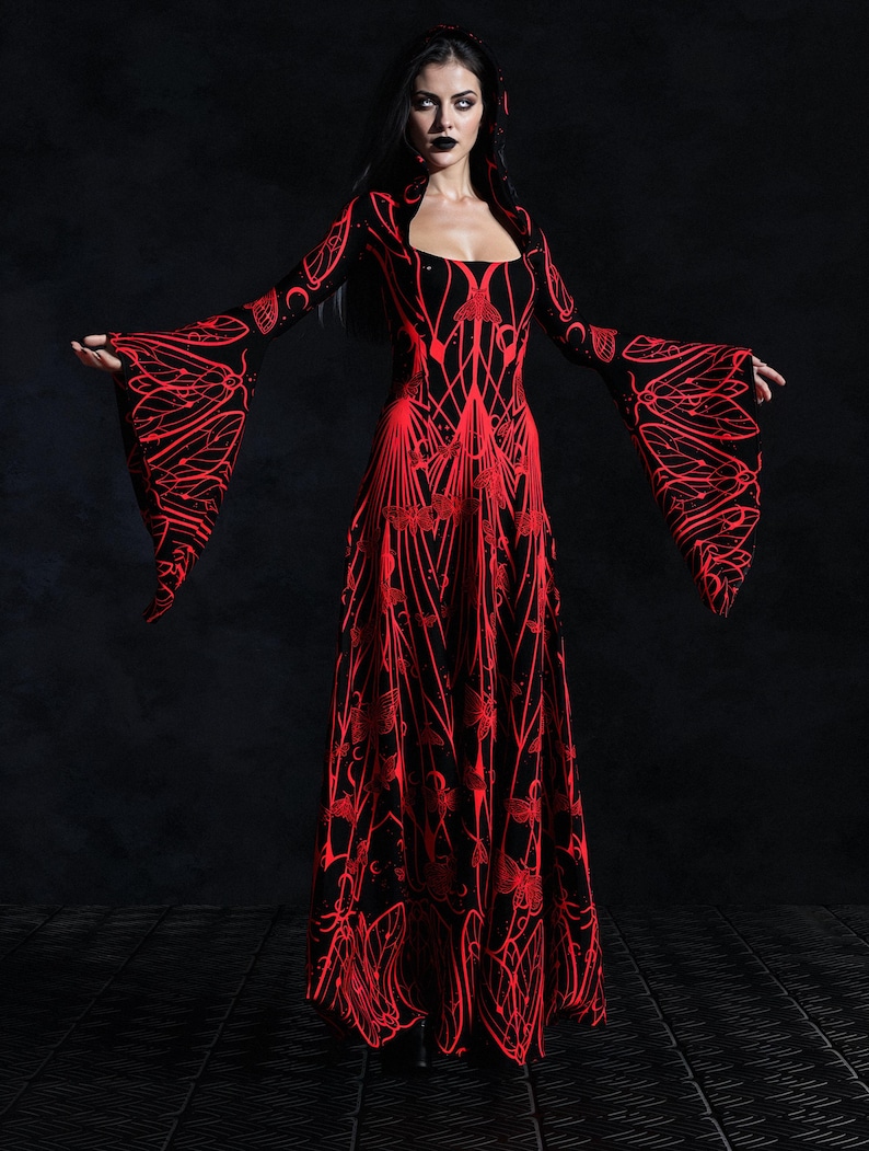 May include: A long, black dress with a red, intricate, floral-like pattern. The dress features long, flared sleeves and a square neckline. The design is symmetrical, with the red pattern standing out against the black fabric. The dress appears to be made of a flowing material.