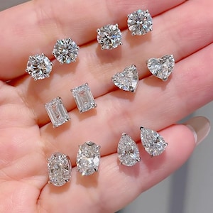 Pode incluir: Uma coleção de brincos de diamante em várias formas: redondos, de coração, corte esmeralda, ovais e em forma de pêra. Os brincos são cravejados em prata ou ouro branco.