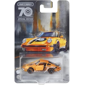Puede incluir: Un coche de juguete amarillo de metal fundido a presión Matchbox 70 aniversario edición especial a escala 1/64 de un Porsche 911 Turbo. El coche tiene detalles negros y una franja negra en el capó. El coche está sobre un fondo blanco.