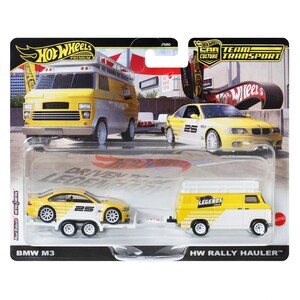 May include: A Hot Wheels Car Team Transport set featuring a yellow and white van and a yellow BMW M3 car. The set includes the text "Driven to be Legendary" and "HW Rally Hauler". The cars have the number "25" on them.