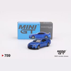 May include: A blue 1/64 scale diecast model car of a Nissan Skyline GT-R R34 V-Spec. The car is on a white background with a box behind it that says "MINI GT" and "Nissan Skyline GT-R ROM V Spec".