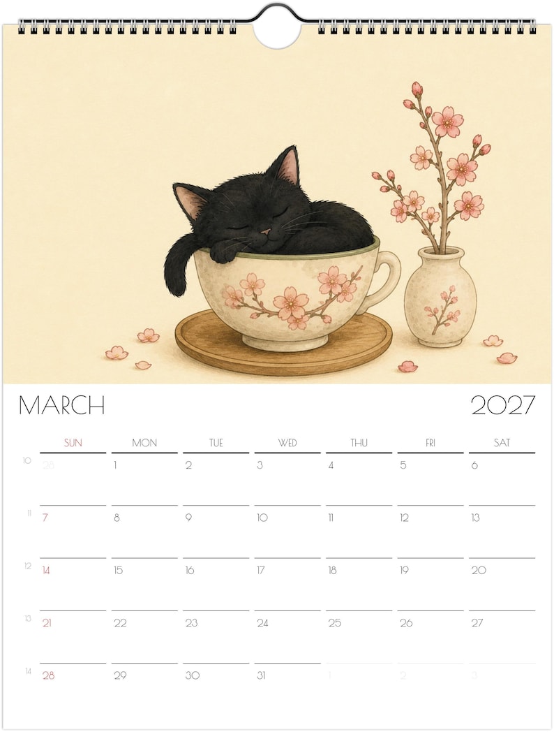 Puede incluir: Un calendario de pared para marzo de 2027 con una ilustraci&oacute;n de un gato negro durmiendo dentro de una taza de t&eacute; color crema decorada con flores de cerezo rosas. Un peque&ntilde;o jarr&oacute;n a juego con ramas de cerezo se sit&uacute;a junto a la taza.