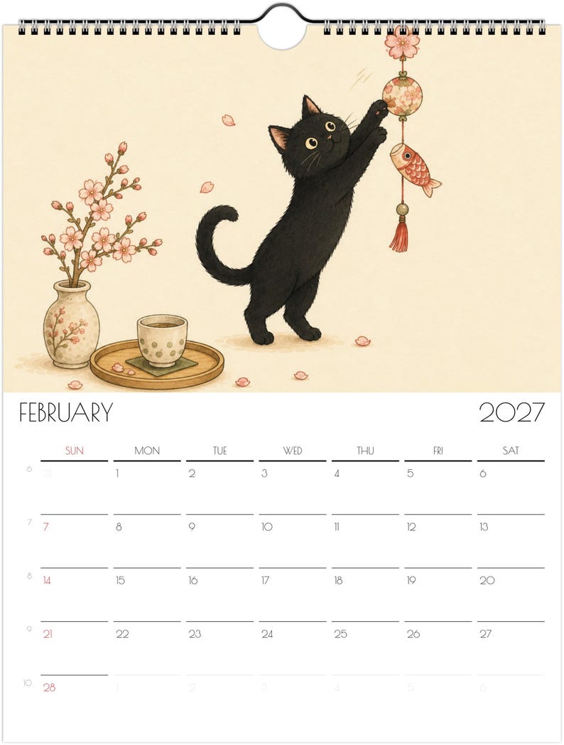 Puede incluir: Una p&aacute;gina de calendario de pared de febrero de 2027 con una ilustraci&oacute;n de un gato negro alcanzando un adorno colgante. A la izquierda, se ven un jarr&oacute;n con flores de cerezo y una peque&ntilde;a taza de t&eacute; sobre una bandeja de madera. La cuadr&iacute;cula muestra el mes.