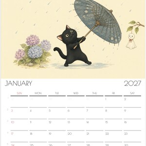 Puede incluir: Un calendario de pared para enero de 2027 con una ilustraci&oacute;n de un gato negro sosteniendo un paraguas azul estampado bajo la lluvia. Junto al gato hay hortensias moradas y azules y una peque&ntilde;a mu&ntilde;eca blanca colgando de una rama.