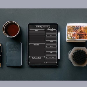 May include: A black and white weekly planner on a tablet with a stylus next to it. The planner has sections for notes, reminders, and a weekly calendar. The text on the planner says "Weekly Planner" and "Week in Review".