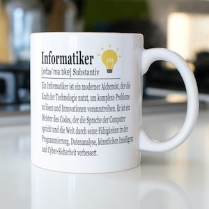 Könnte beinhalten: Weiße Keramiktasse mit einer schwarz-weißen Definition von "Informatiker" und einer Glühbirnengrafik. Der Text lautet: "Informatiker [informatike] Substantiv Ein Informatiker ist ein moderner Alchemist, der die Kraft der Technologie nutzt, um komplexe Probleme zu lösen und Innovationen voranzutreiben. Er ist ein Meister des Codes, der die Sprache der Computer spricht und die Welt durch seine Fähigkeiten in der Programmierung, Datenanalyse, künstlichen Intelligenz und Cyber-Sicherheit verbessert."