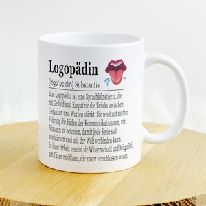 Op de afbeelding: Witte keramische mok met een zwart-wit ontwerp. De mok heeft het woord "Logopädin" met een definitie in het Duits. De mok heeft een handvat en een uitstekende tong met een kwijl-emoji.