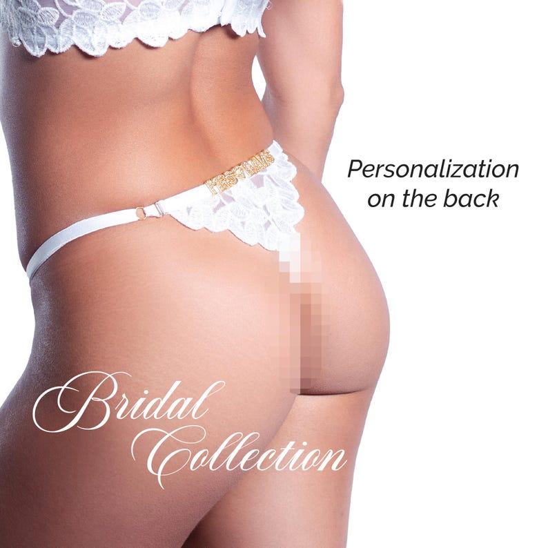May include: White lace thong with gold accents. The thong features a delicate floral lace design and the text "Bridal Collection". The text "Personalization on the back" is also visible.