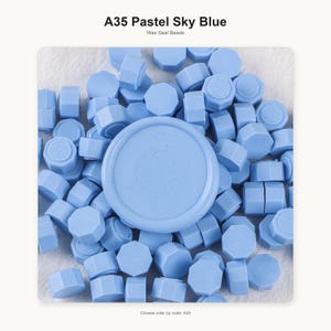 May include: A collection of pastel sky blue wax seal beads, labeled A35 Pastel Sky Blue Wax Seal Beads. The beads are small, octagonal, and circular shapes in a uniform light blue color, scattered together to form a dense, textured pile.