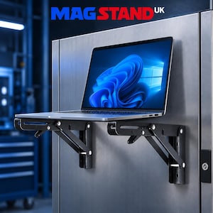 May include: A silver laptop with a blue screen display resting on two black foldable metal brackets attached to a vertical stainless steel surface. The text MAGSTAND UK is visible in blue and red letters at the top of the image.