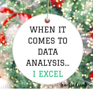May include: White ceramic Christmas ornament with black text that reads "When it comes to data analysis... I excel." The text "I excel" is in green.