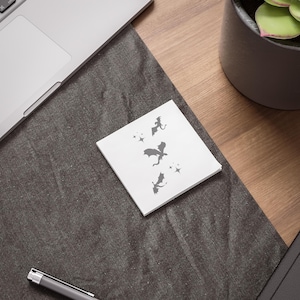 May include: A white card with a design of four black dragons flying in a formation with stars around them.
