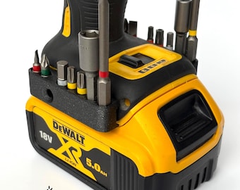 May include: A yellow and black DeWalt XR 18V 5.0Ah Li-Ion battery with a magnetic bit holder attached. The holder has a variety of drill bits and a magnetic top. The battery has the text "DEWALT XR 18V LI-ION 5.0Ah" printed on it. The battery is made in Germany. The holder is made by MBEEngineering.