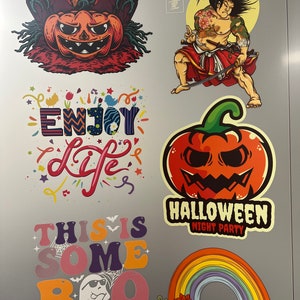 May include: A collection of six colorful stickers featuring a pumpkin with tombstones, a samurai with a sword, the text ENJOY LIFE, a pumpkin with the text HALLOWEEN NIGHT PARTY, the text THIS IS SOME BOO SHEET with a ghost, and a rainbow with skulls.