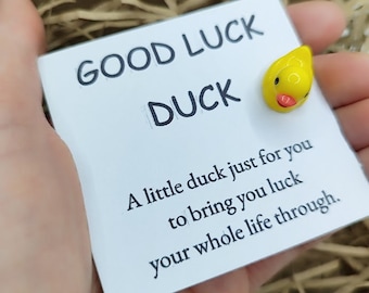 May include: A white card with the text "GOOD LUCK DUCK" and the message "A little duck just for you to bring you luck your whole life through." A small yellow rubber duck is attached to the card.