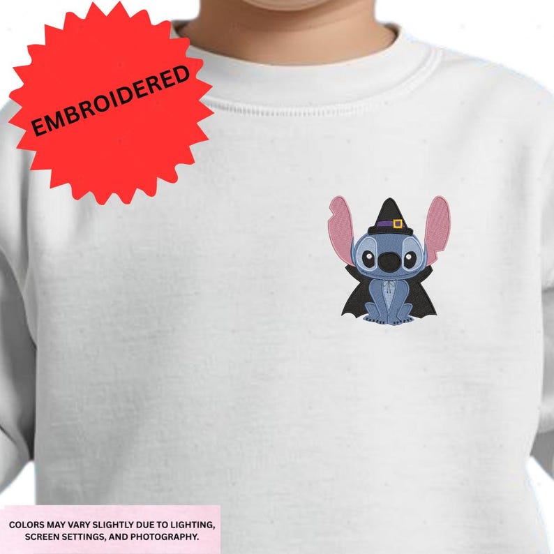 a white t-shirt with a small embroidered character, specifically a blue bat-like creature, on the front.