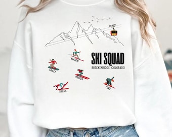 May include: White sweatshirt with a black graphic of a mountain range, skiers, and a ski lift. The text "SKI SQUAD BRECKENRIDGE, COLORADO" is printed in black. Names of skiers are printed below the skiers. The date "DEC 2025" is printed above the ski lift.
