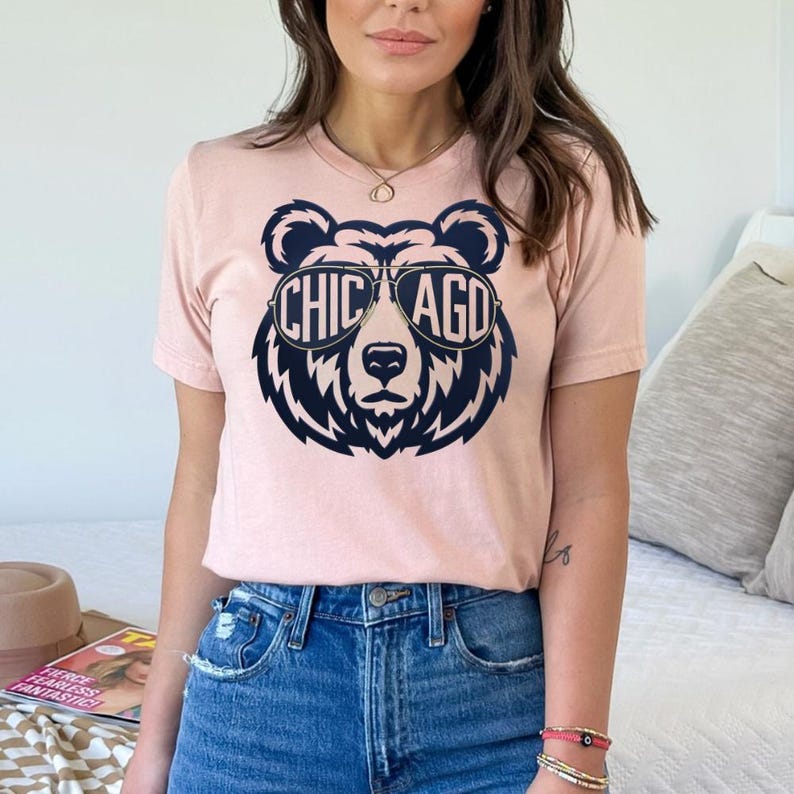 A woman wearing a pink t-shirt with a graphic of a bear wearing sunglasses and the text "CHICAGO" printed on it.