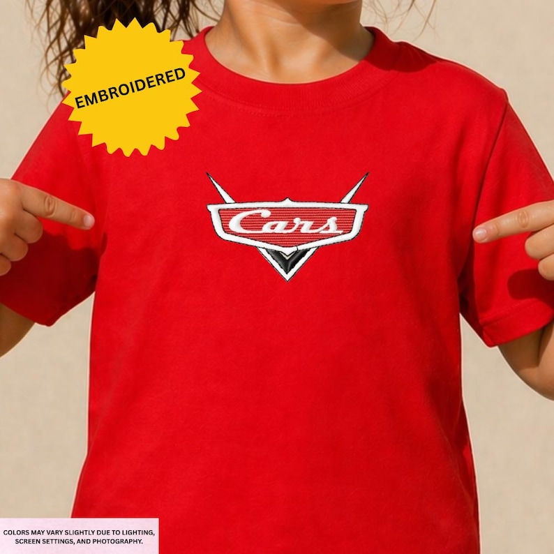 A person wearing a red t-shirt with the Cars logo embroidered on it.