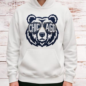 A white hoodie with a graphic design of a bear wearing sunglasses and the text "CHICAGO" printed on it.