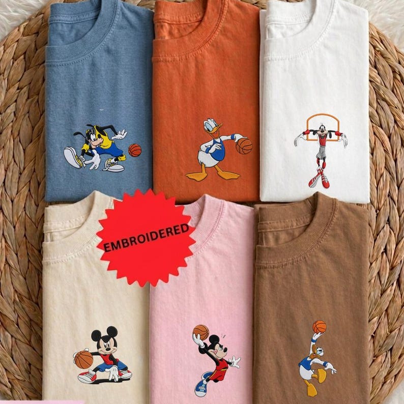 A collection of t-shirts featuring cartoon characters, including Mickey Mouse, Donald Duck, Goofy, and other basketball players, along with basketballs.