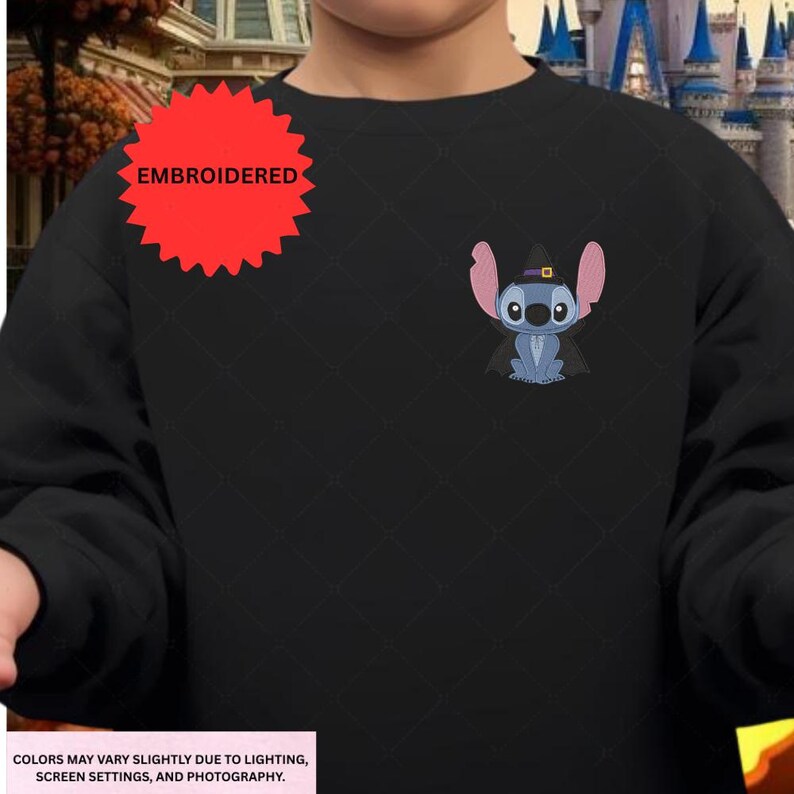 Embroidered character on a black sweater with a castle in the background.