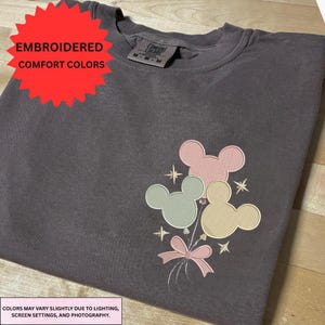 a gray t-shirt with a colorful Mickey Mouse-themed embroidered design on the front.