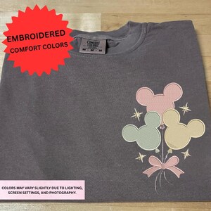 a gray t-shirt with a colorful Mickey Mouse design on the front.