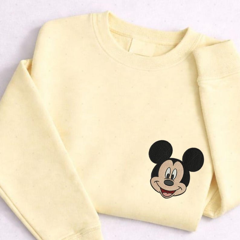 A yellow sweater with a Mickey Mouse embroidered on the front.