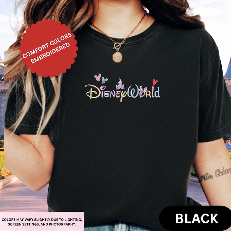 A person wearing a black t-shirt with the Disney World logo embroidered on it.