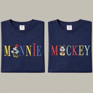 two blue t-shirts with the word "Minnie" and " Mickey" printed on them, along with illustrations of Minnie Mouse and Mickey Mouse.