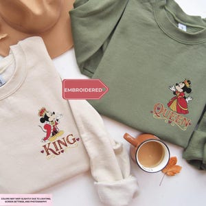 two t-shirts with a Disney character design, a cup of coffee, and a leaf, all laid out on a white surface.