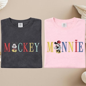 two t-shirts with the word "MICKEY" and the character Minnie Mouse printed on them.