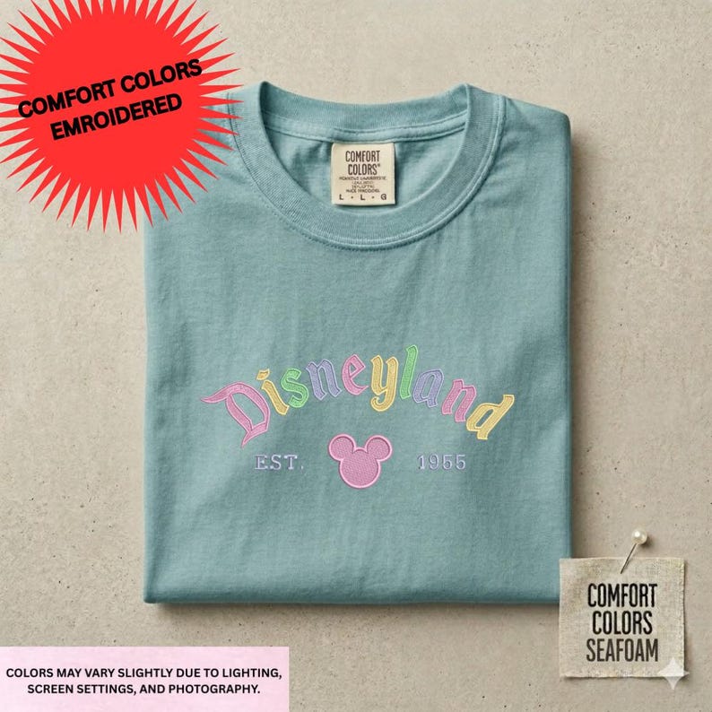 a light blue t-shirt with a Disneyland logo and text, along with a tag and a note about the colors of the shirt.