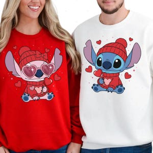 A woman wearing a red sweater with a cartoon character and a man wearing a white sweater with a cartoon character.