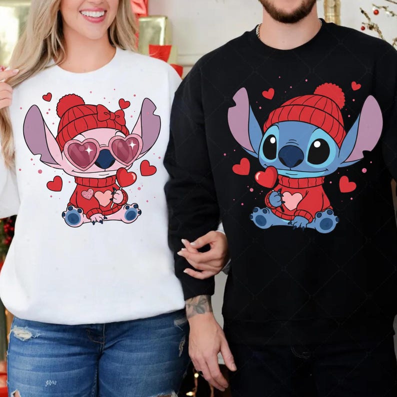 A woman wearing a white sweater with a pink and blue cartoon character and a man wearing a black sweater with a blue cartoon character.