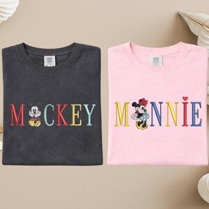 two t-shirts with the word "MICKEY" and the character Minnie Mouse printed on them.