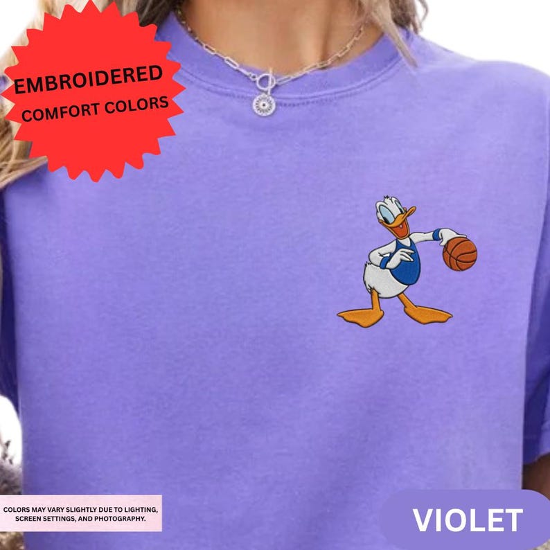a purple t-shirt with a cartoon duck holding a basketball.